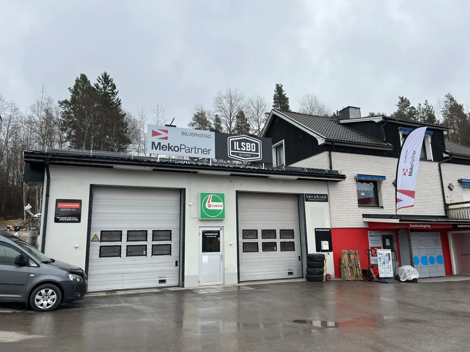 Färgbild - exteriör av bilverkstad med fasadskyltar.
