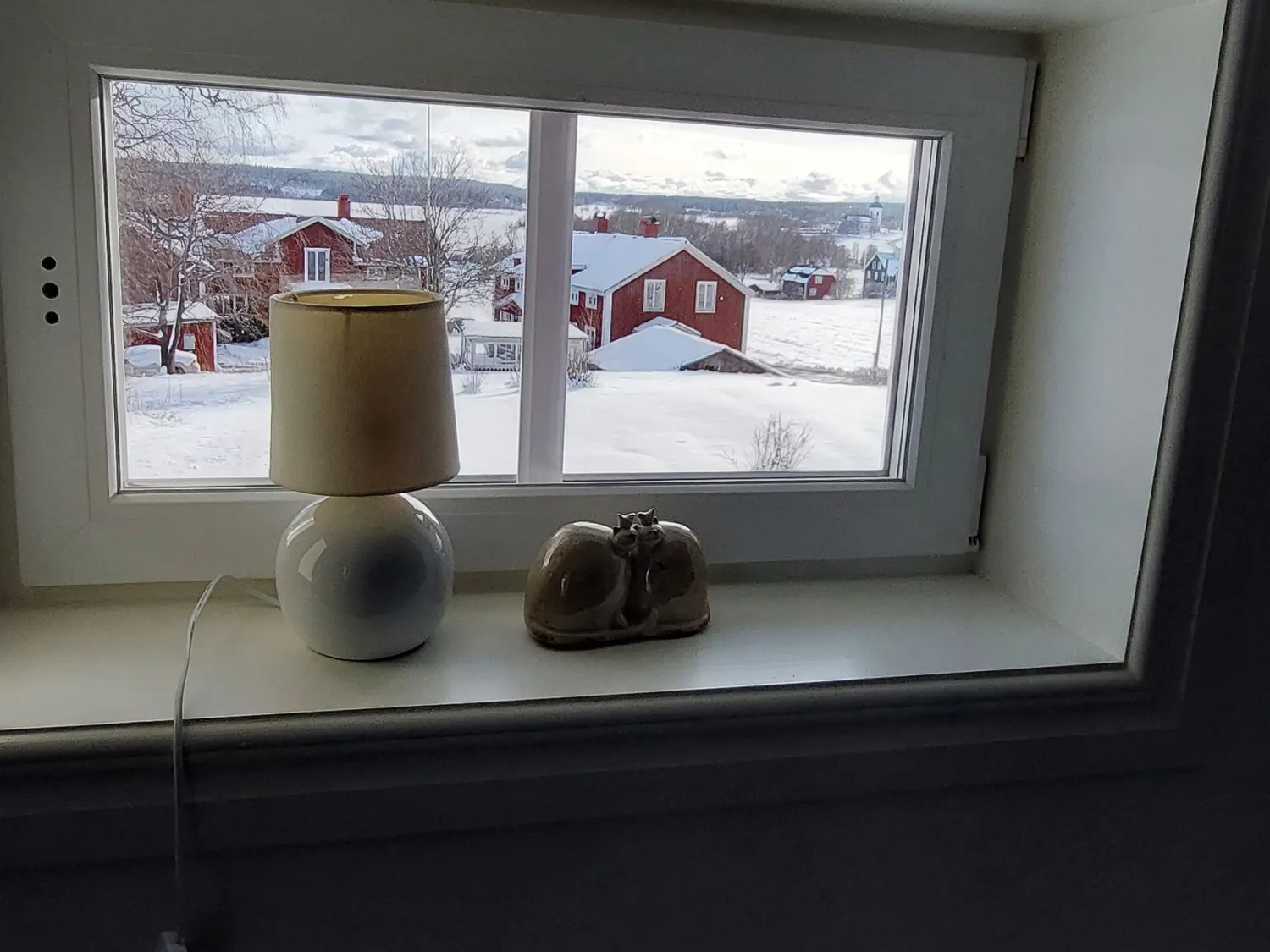 Utsikt från litet fönster över närliggande hus 