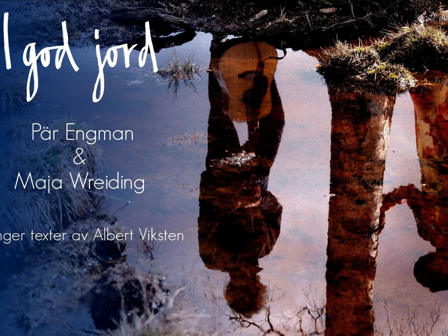 Färgbild - naturbild med två personer upp ochnedvända. Vit text på bild: I God Jord, Pär Engman och Maja Wreiding