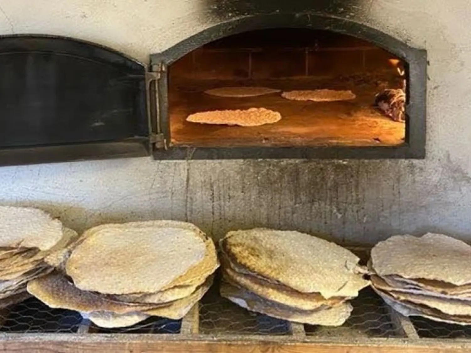 Färgbild - en närbild på nybakt hällbröd vid eldbakande ugn.