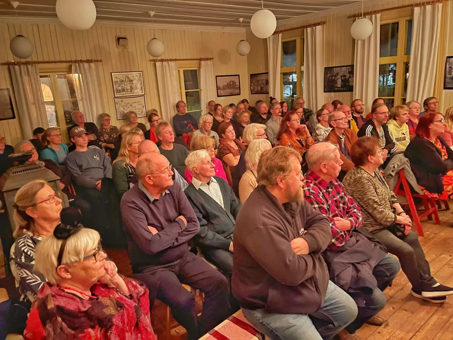 Färgbild - sittande publik i en stor sal inomhus.