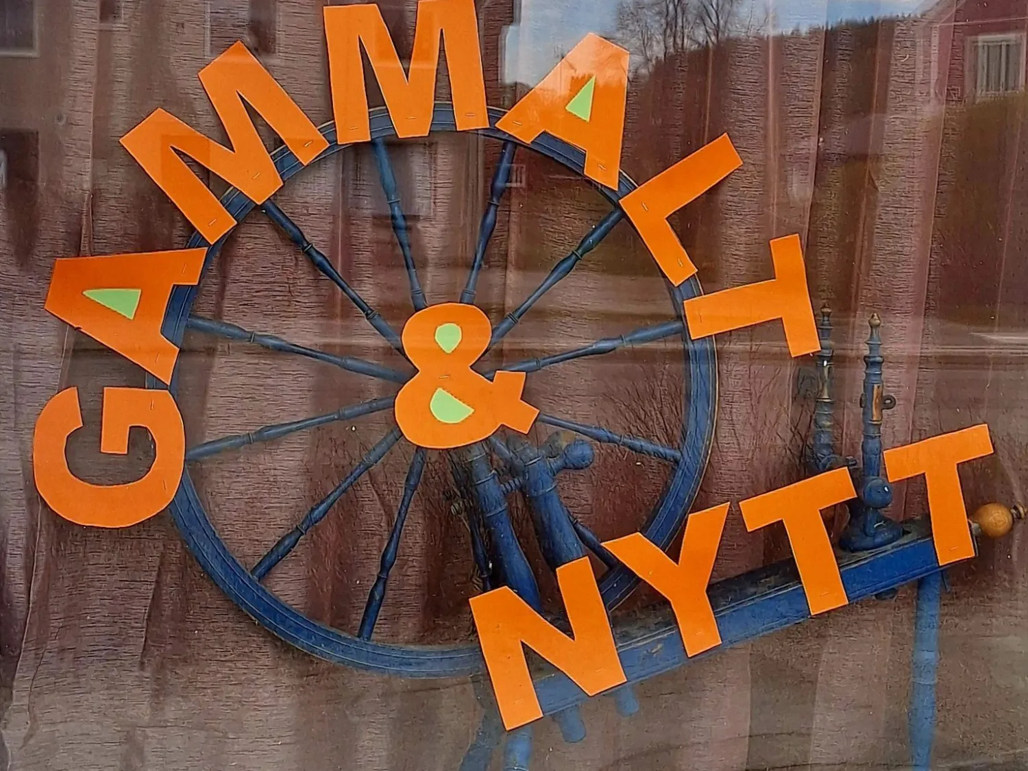 Färgbild - närbild på butiksfönster med text: gammalt & nytt
