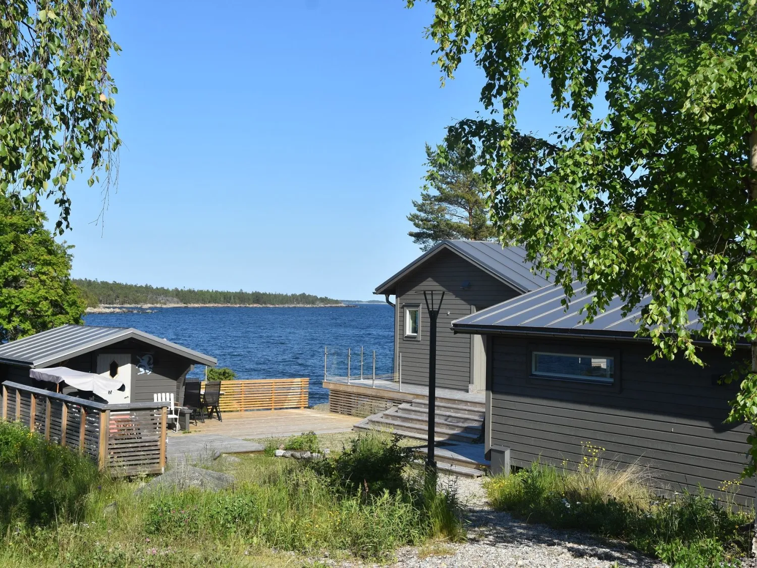 Exteriör grå stugor med havet i bakgrunden