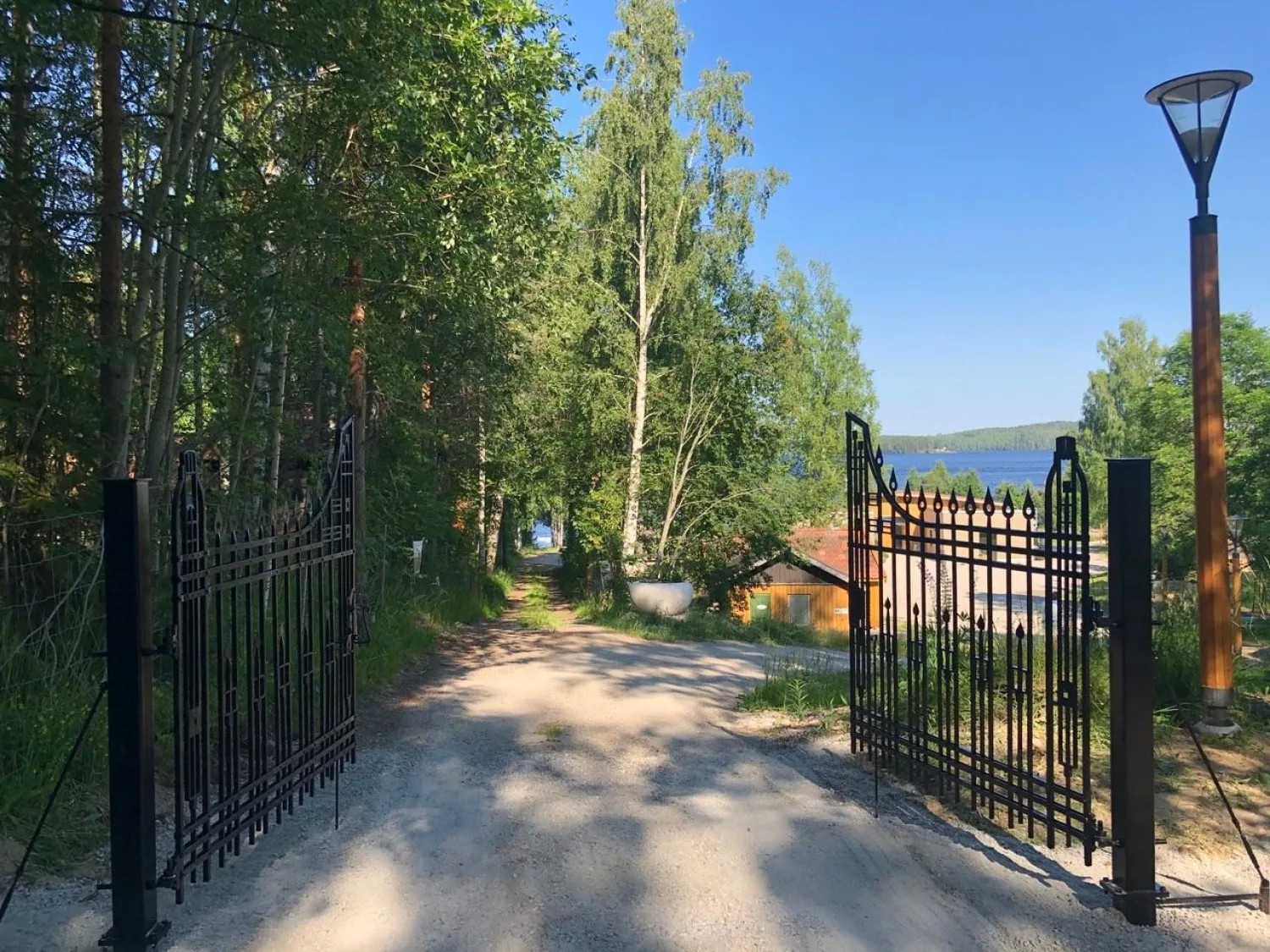En infart med grind till campingområde med omgivande natur
