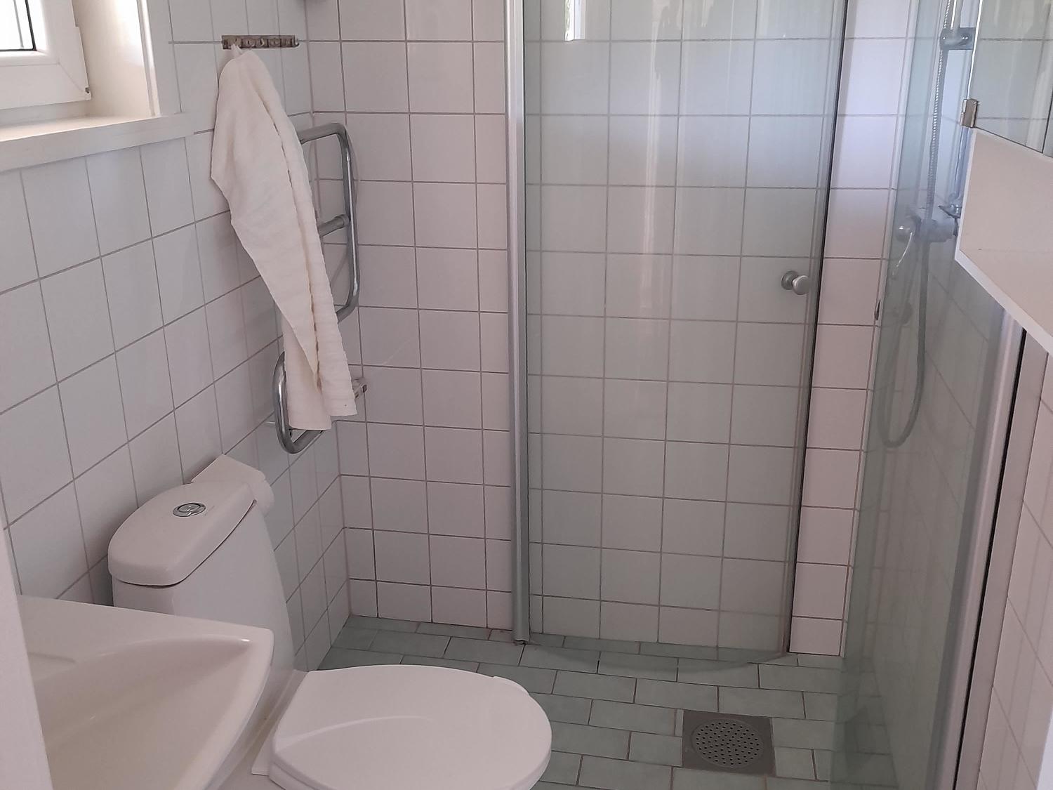 Interiör badrum med wc, tvättställ och duschhörna