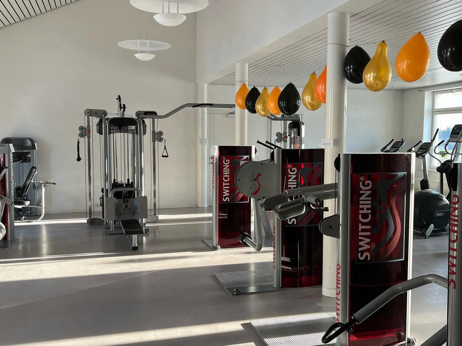 Inomhusbild i färg. Gymlokal med träningsmaskiner