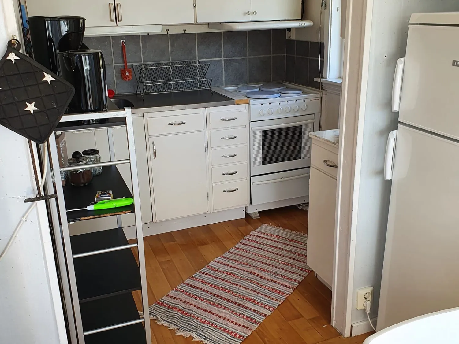 Färgbild - interiör kök med vita skåp, spis etc