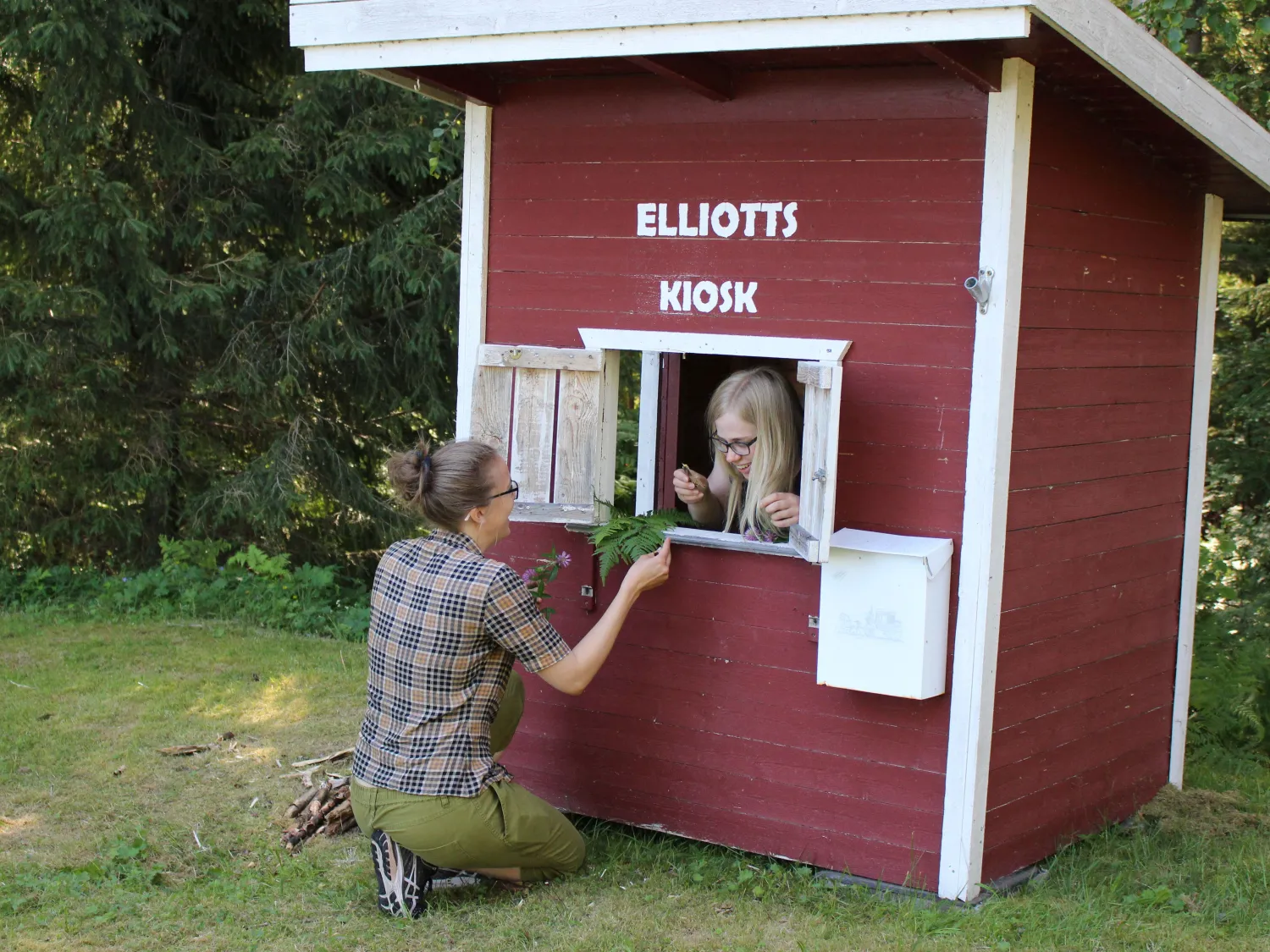 Två vuxna som leker som barn vid en kiosk