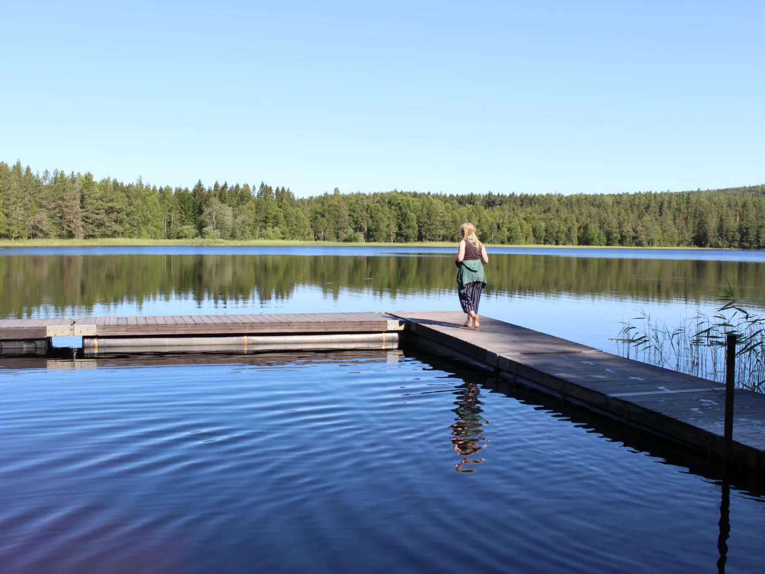 Kvinna går på brygga i Barrtjärn