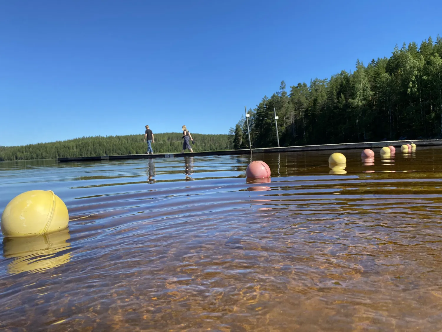 Tåvå personer går på bryggan i Bjärtsjön