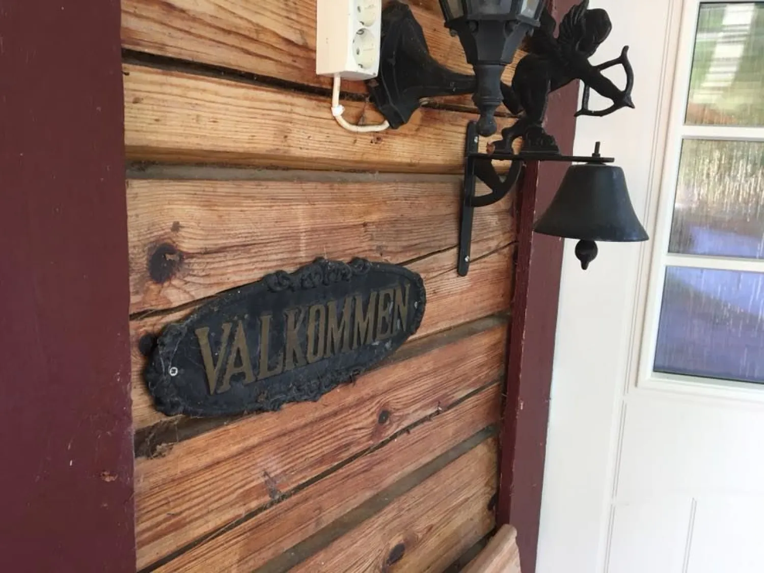 Ingång med ringklocka och välkomstskylt