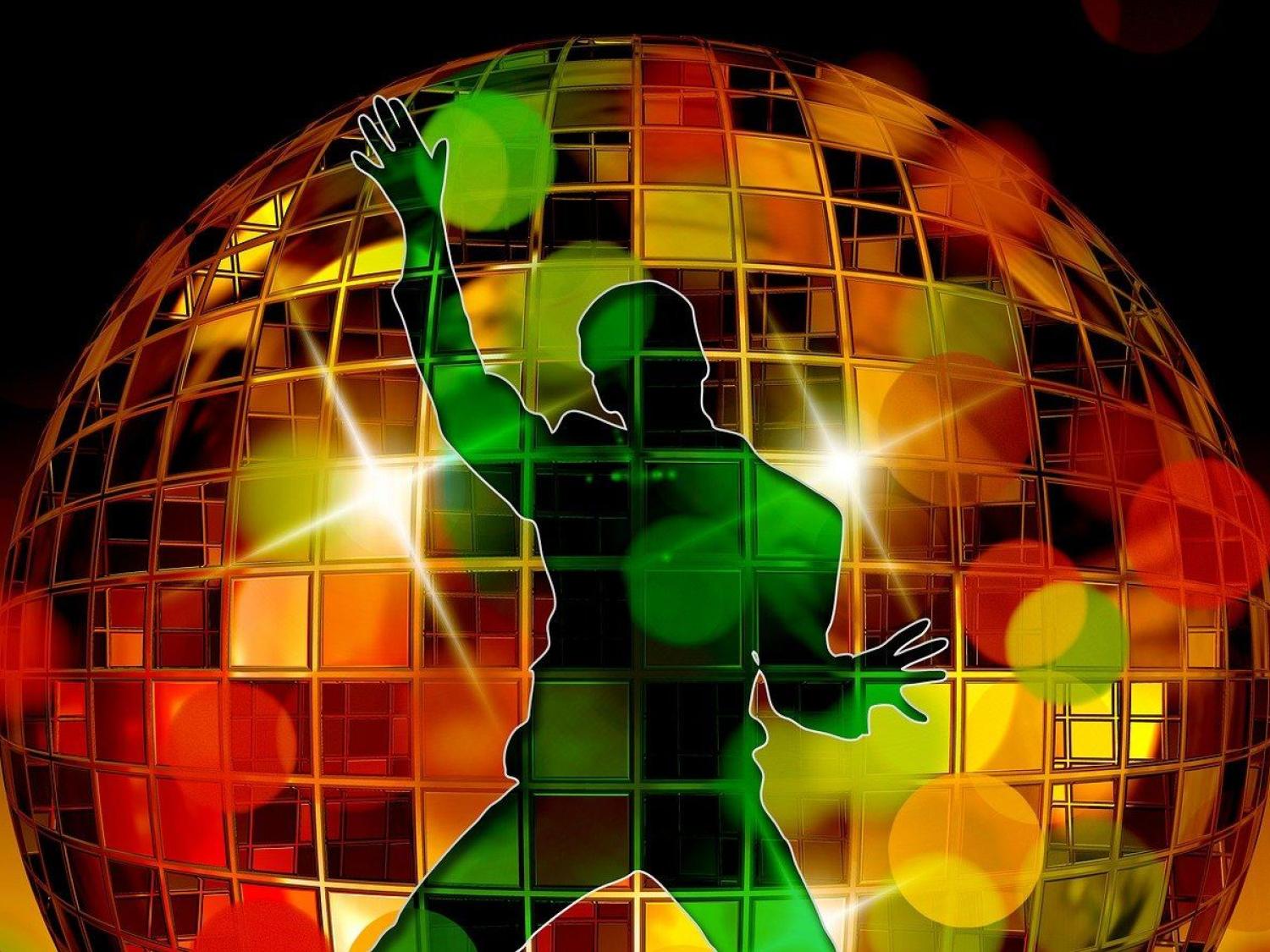 Färgbild - närbild på färgglad discokula med en grön siluett i förgrunden 