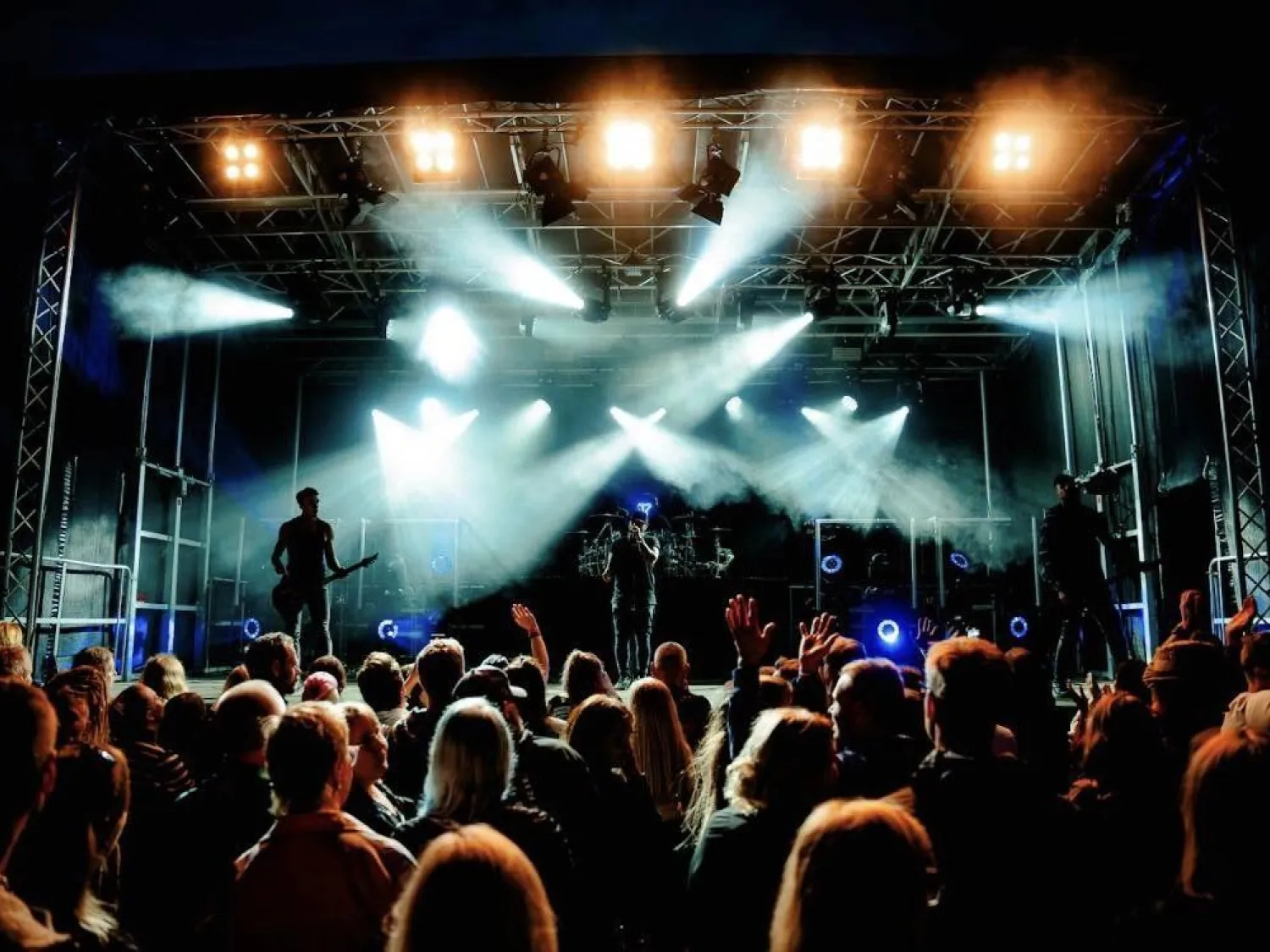 Colour picture - a crowd of people in front of a music stage.