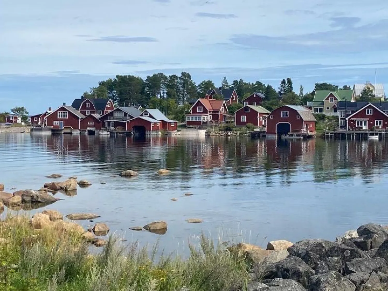 Färgbild - utsikt över röda sjöbodar vid havet