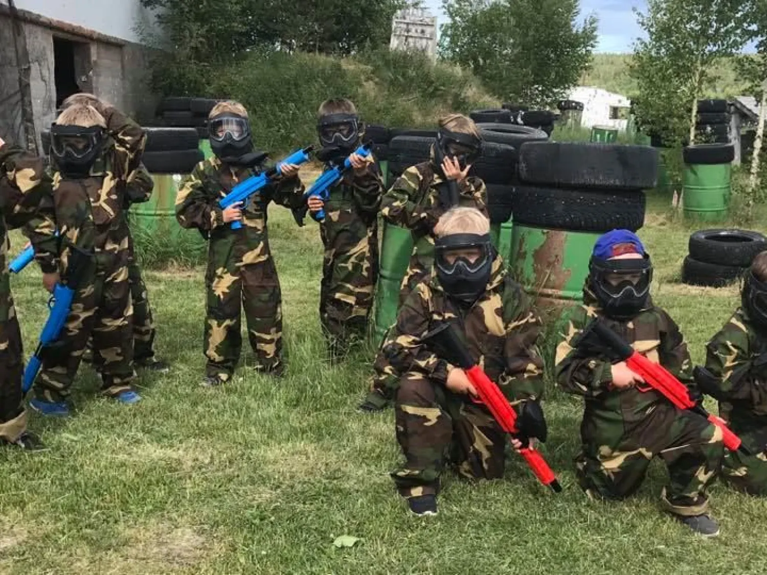 Grupp med personer uppklädda för paintballspel