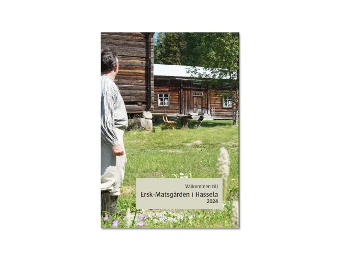 Färgbild på framsida av broschyr - Ersk-Matsgårdens program 2024. Man vid gammal timrad hälsingegård.