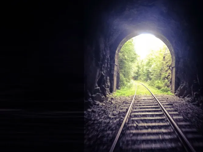 Färgbild - mörk tunnel med tågräls. Dellenbanan.