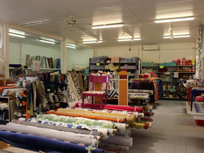Färgbild - butiksinteriör med textilier på hyllrader.