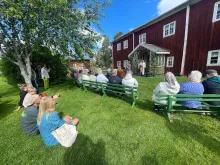 Fågelsjö gammelgård - Dalarna - Ljusdals kommun Färgbild - Fågelsjö gammelgård. Exteriör av röd och vit byggnad och människor sittande utanför.