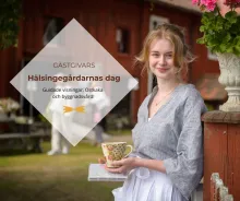 Gästgivars - Hälsingegård Färgbild - porträtt av ung kvinna utomhus framför röd byggnad. Textplatta på bilden