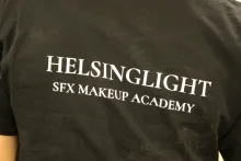 Helsinglight Baksidan av en svart t-shirt med vit text.