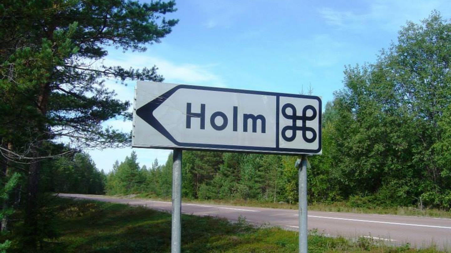 Vägskylt vid väg - med text Holm och fornminnesmärke.