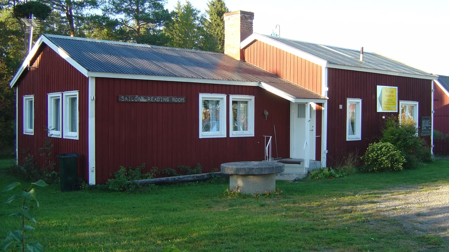 Rödmålad stuga med vita knutar.