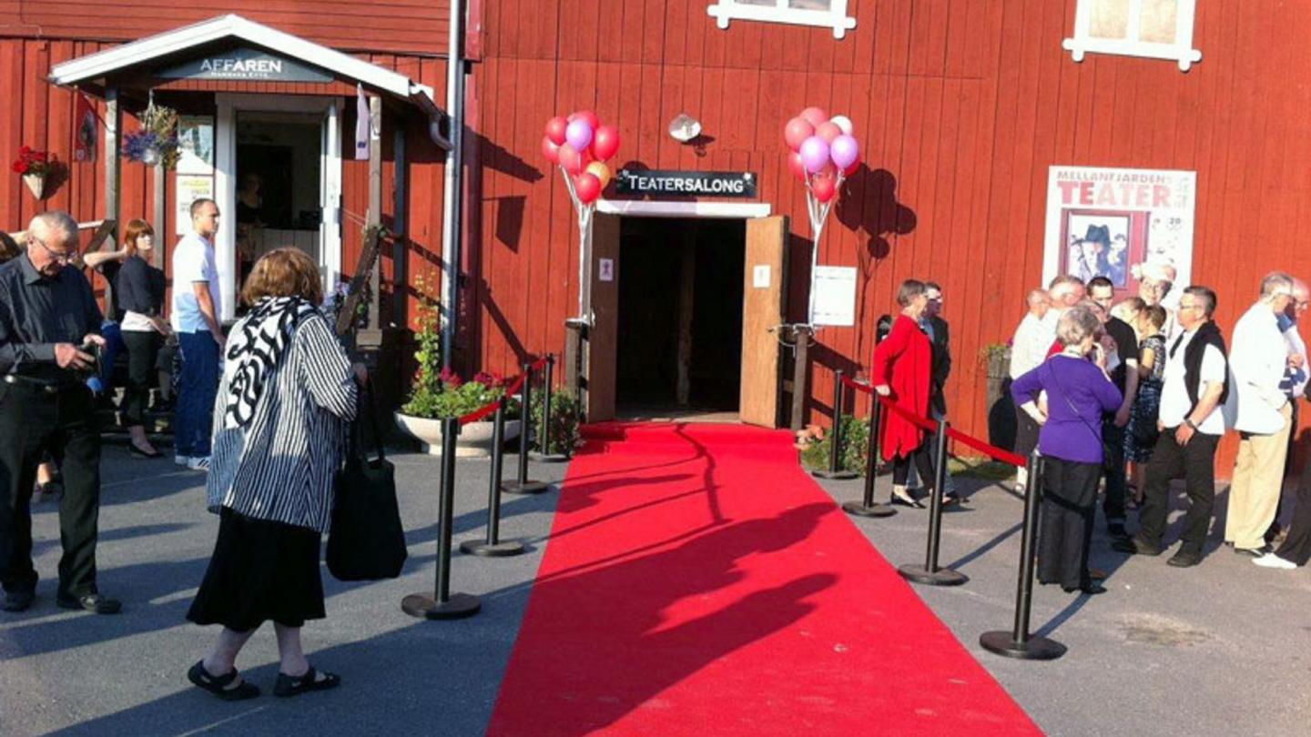 Entre till Mellanfjärdens Teaterlokal med röda mattan utlagd och folk som väntar utanför.