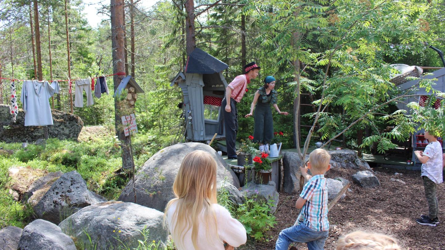 Trollkarlen Filijokus utanför sitt hus i Trolska Skogen med barn som publik.