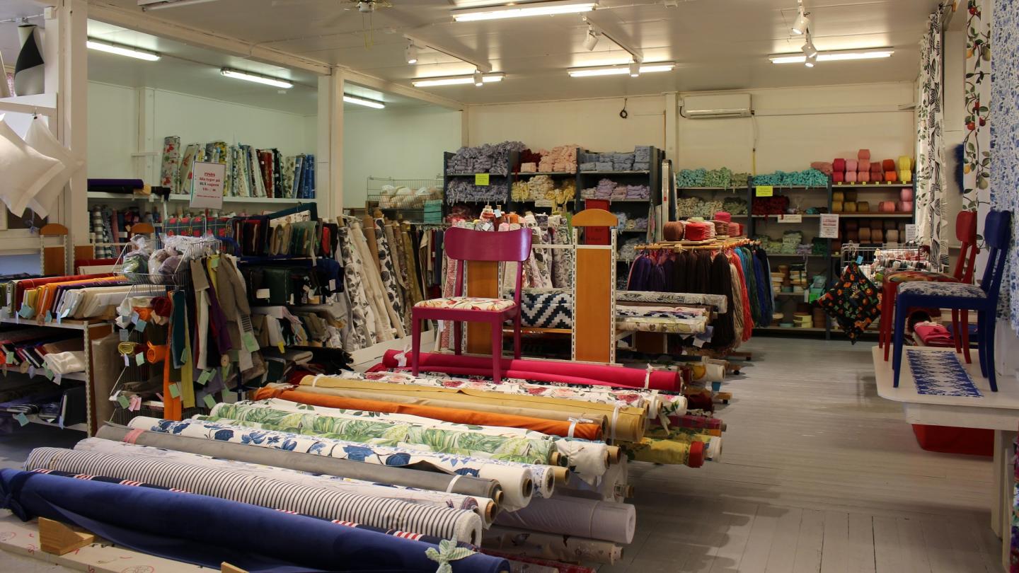 Textilier på hyllor och bord i butik